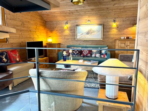 un salon avec un canapé et une table dans l'établissement Le Chalet de Nabor, aux Gets