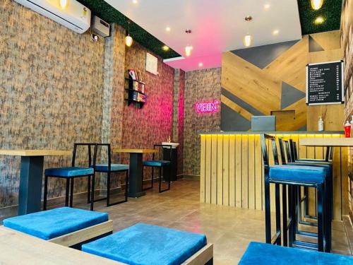 un bar con taburetes azules en un restaurante en Nagaon Homestay, en Nowgong