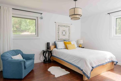 a bedroom with a bed and a chair and a window at Blue House On The Hill - Year Round Cottage in Turriff