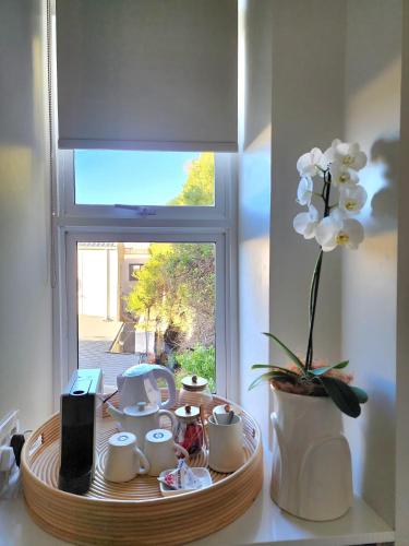 a tray with cups and flowers on a table in front of a window at Waves of Grace Seafront Villa in Herolds Bay