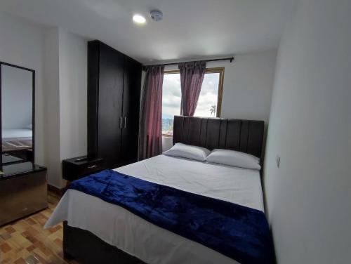a bedroom with a bed and a large window at Apartahotel JDK in Armenia