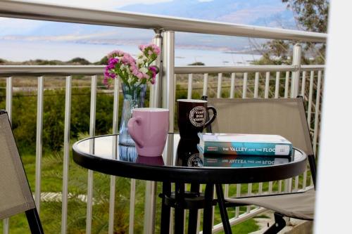a table with books and a cup and flowers on a porch at Sea Sight Vibes in Frangokastello