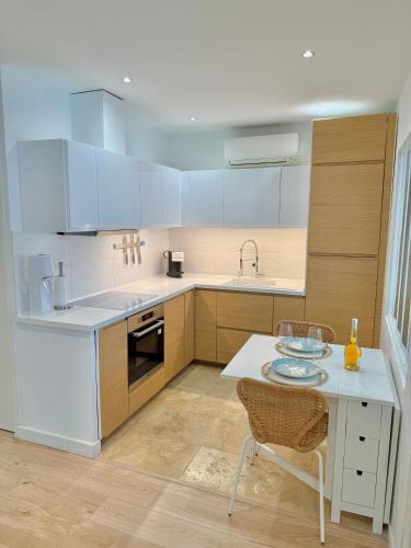 - une cuisine avec des appareils blancs, une table et des chaises dans l'établissement T3 6 personnes de 60m2 au coeur de ville, terrasse et parking gratuit, à Saint-Raphaël