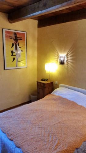 une chambre avec un lit et un tableau au mur dans l'établissement La Maison aux Volets Bleus, à Saint-Clément