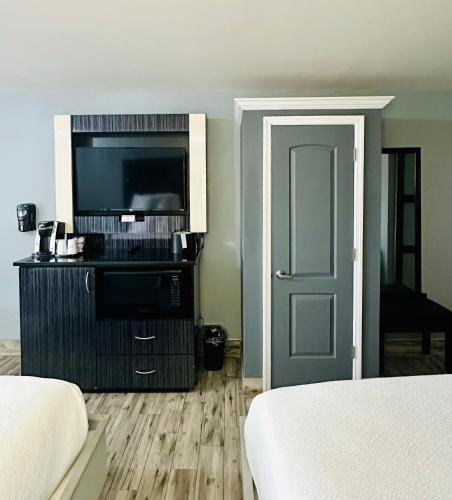 a room with a bed and a television and a door at Historic Waterfront Marion Motor Lodge in downtown St Augustine in Saint Augustine