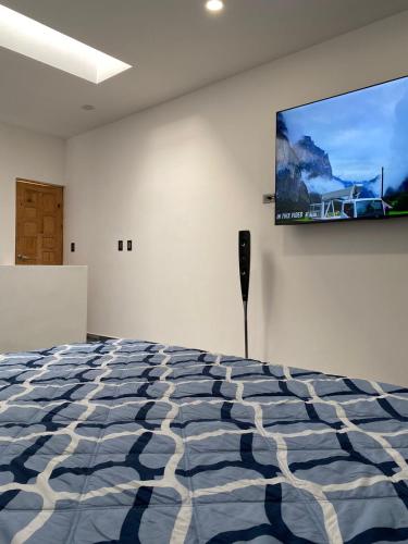 a room with a bed and a flat screen tv on the wall at Departamento Arrecife in La Paz