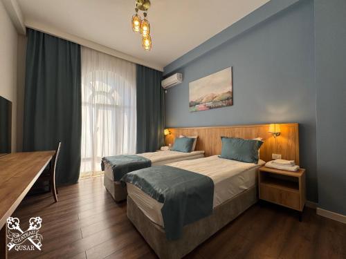 a hotel room with two beds and a window at Chateau Qusar Hotel & Restaurant in Qusar
