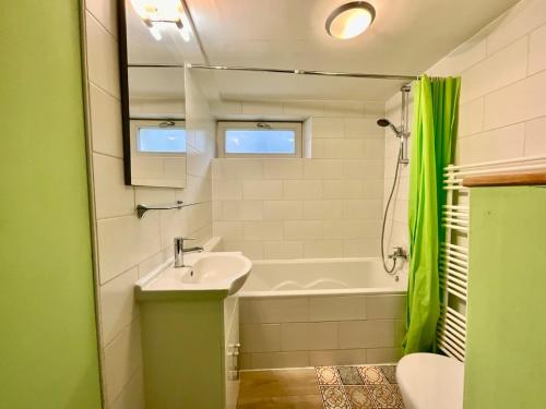 une salle de bain avec un lavabo et une baignoire dans l'établissement Le Duplex Géromois, beautiful apartment & city center, à Gérardmer