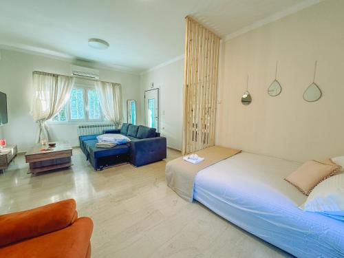 a bedroom with a bed and a living room with a couch at Sea Lullaby in Drymonas