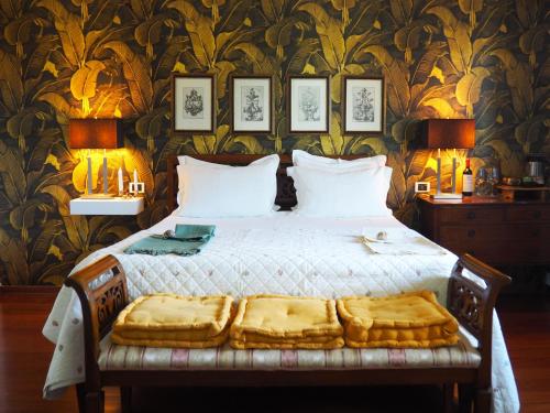 a bed in a bedroom with a wall with wallpaper at Aura Relais in Numana