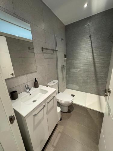a bathroom with a toilet and a sink and a shower at Apartamentos EL SERRÓN Colombres in Colombres
