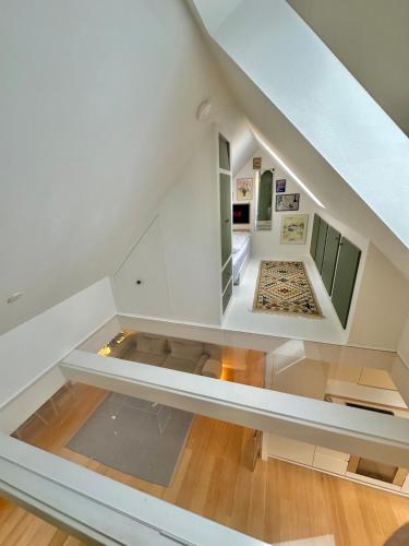 an attic room with a couch and a staircase at Central rooftop apartment by ARoS with balcony in Aarhus