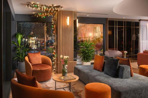 a living room with a couch and chairs at NH Catania Centro in Catania