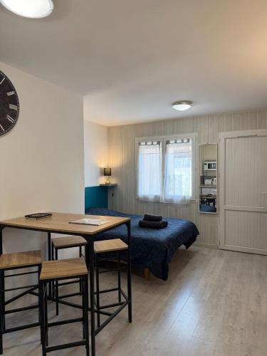 Un dormitorio con una cama y una mesa y sillas. en Studio confort - Portet-sur-Garonne, en Portet-sur-Garonne