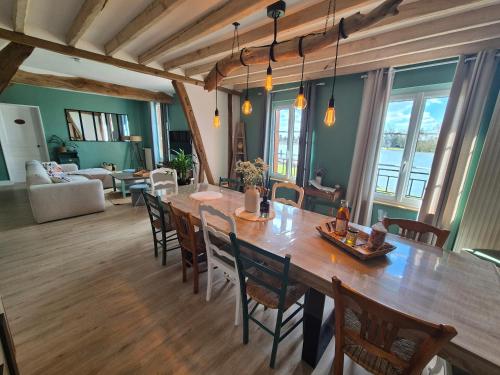 une salle à manger avec une grande table et des chaises en bois dans l'établissement Le Cœur du Bien-être - Gîte grande capacité - 6 chambres - Superbe emplacement - Vue Seine - Décoration soignée - Coin touristique, aux Andelys