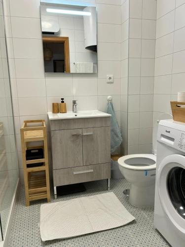 a bathroom with a sink and a toilet and a washing machine at Tavira Garden- 2 bedrooms-2pools-2 balconies in Tavira