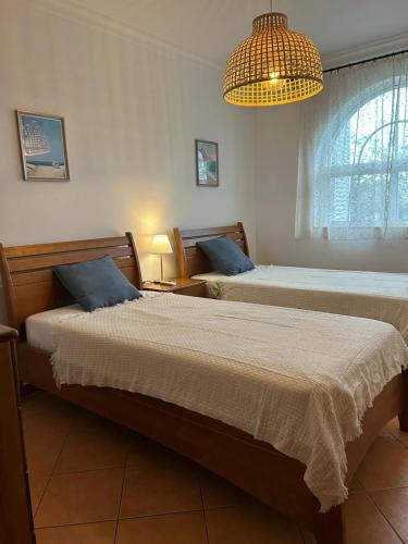 a bedroom with two beds and a chandelier at Tavira Garden- 2 bedrooms-2pools-2 balconies in Tavira