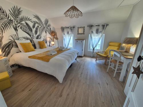 a bedroom with a large bed and a table and chairs at Le Cœur du Bien-être - Gîte grande capacité - 6 chambres - Superbe emplacement - Vue Seine - Décoration soignée - Coin touristique in Les Andelys