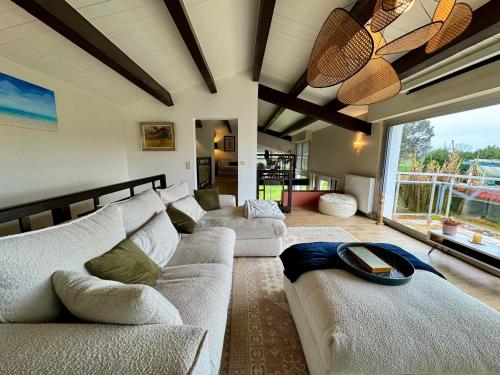 un salon avec deux canapés et une grande fenêtre dans l'établissement La Villa - Piscine - Billard, à Belleville-sur-Vie