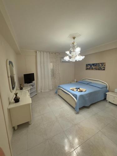 a bedroom with a blue bed and a chandelier at Casa Vacanze Miramare in Porto Empedocle