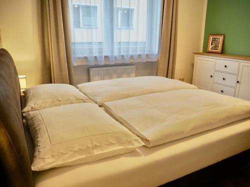 a bed with two pillows on it with a window at Apartment Astrid in Zell am See