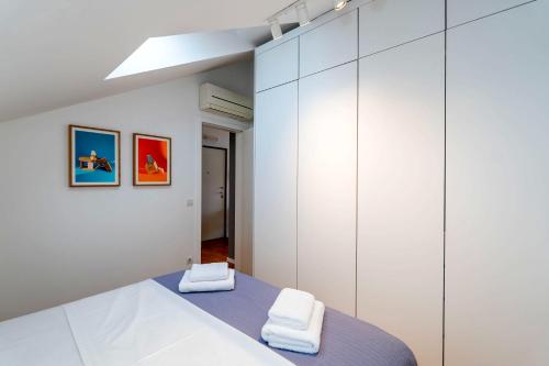 a room with white walls and a bed with towels at Boutique Apartment Ana in Dubrovnik