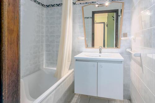 un bagno bianco con lavandino e vasca di Roya G7 a Koksijde