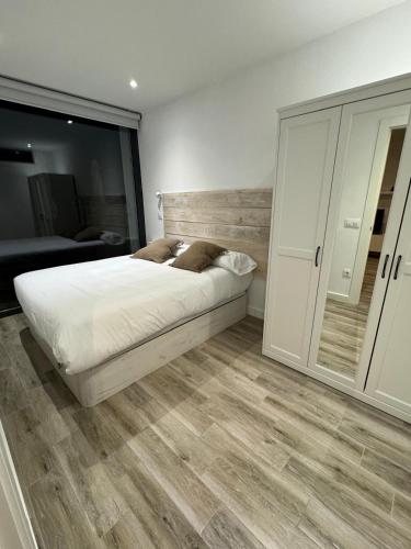 a bedroom with a bed with a wooden headboard at Apartamentos EL SERRÓN Colombres in Colombres