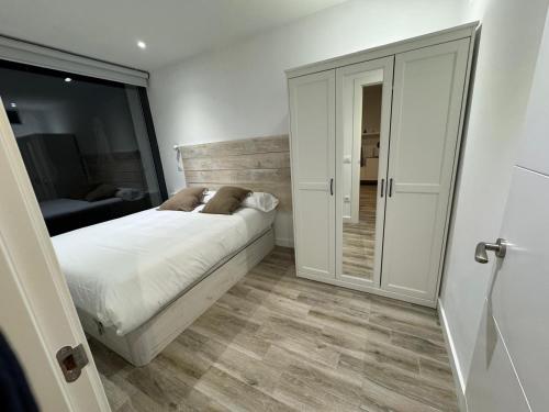 a bedroom with a bed and a sliding glass door at Apartamentos EL SERRÓN Colombres in Colombres