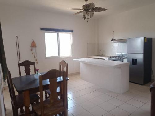 a kitchen with a table and a refrigerator at Casa paraiso in Maito