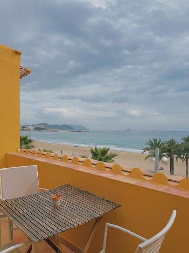 a balcony with a table and a view of the beach at Kiboko Beach in Villajoyosa