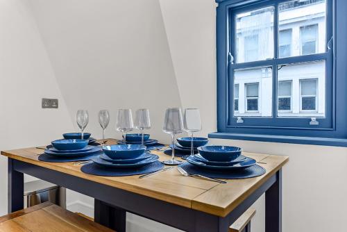 a table with plates and wine glasses on it at Bright and Spacious 2 bed apartments in Central London in London