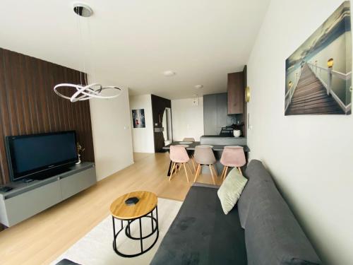 a living room with a couch and a table at NEW apartment with free garage parking near the airport in Prievoz