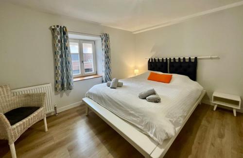 une chambre avec un grand lit blanc et une fenêtre dans l'établissement La Roche du Rain, bel appartement & centre-ville, à Gérardmer