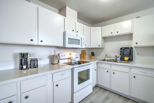 a white kitchen with white cabinets and appliances at Vegas Getaway Near Strip! Sleeps 6! in Las Vegas