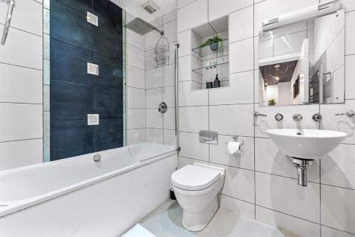 a white bathroom with a toilet and a sink at Bright and Spacious 2 bed apartments in Central London in London