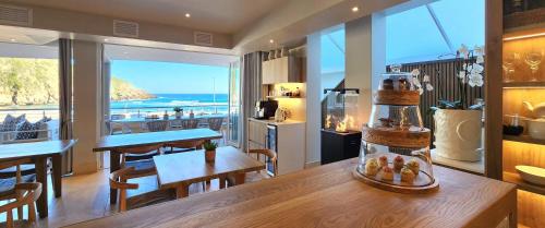 a kitchen and dining room with a view of the ocean at Waves of Grace Seafront Villa in Herolds Bay