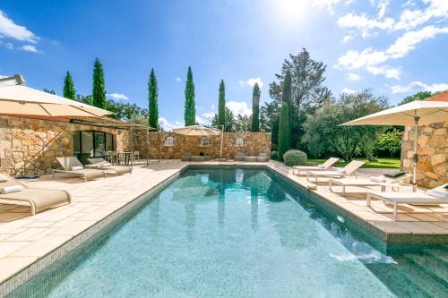 a swimming pool with lounge chairs and a house at Beautiful property near Fayence in Saint-Paul-en-Forêt