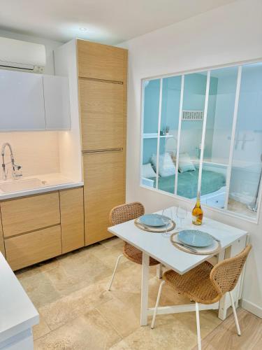 d'une cuisine avec une table blanche et deux assiettes. dans l'établissement T3 6 personnes de 60m2 au coeur de ville, terrasse et parking gratuit, à Saint-Raphaël