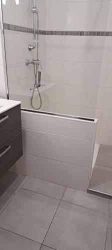 une salle de bain avec une douche avec une porte vitrée dans l'établissement La Côte Bleue, à Martigues