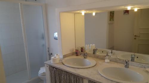 a bathroom with two sinks and a large mirror at Al Sandalyon in Quartu SantʼElena