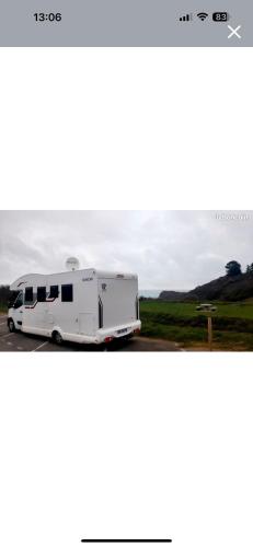 un wagon blanc garé dans un parking dans l'établissement Camping car moderne tout équipé lit central à Rennes, à Cesson-Sévigné