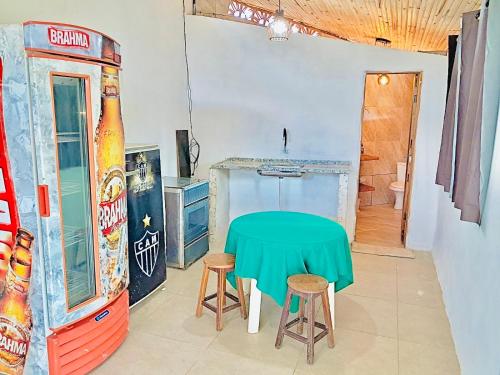 una stanza con un tavolo e un distributore di bibite di Hospedaria Paraíso das Águas Suíte independente KitBet com cozinha completa a Itabirito