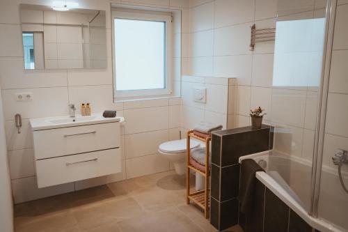 a bathroom with a sink and a toilet and a tub at Little Break in Röfingen