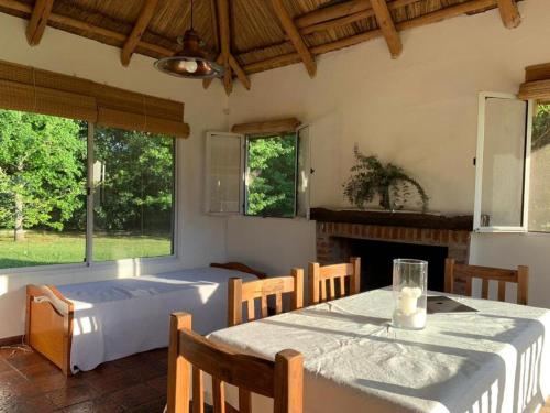 a dining room with a table and a fireplace at La Calma casa quinta in Capilla del Señor