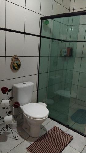 a bathroom with a toilet and a glass shower at casa da meg in Tiradentes