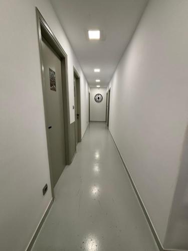 a long hallway with a clock on the wall at Rooms the other side of the island by Patitiri in Saterlí