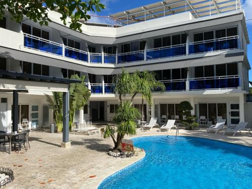 a building with a swimming pool in front of a building at New Garden Hotel in Sosúa