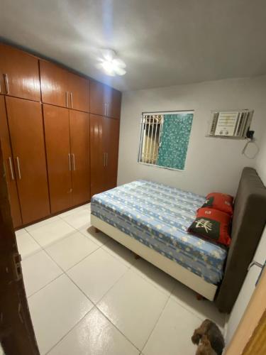 a small bedroom with a bed and cabinets in it at Casa raízes do bem in São Pedro da Aldeia
