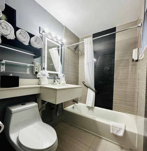 a bathroom with a toilet and a sink and a tub at Historic Waterfront Marion Motor Lodge in downtown St Augustine in Saint Augustine